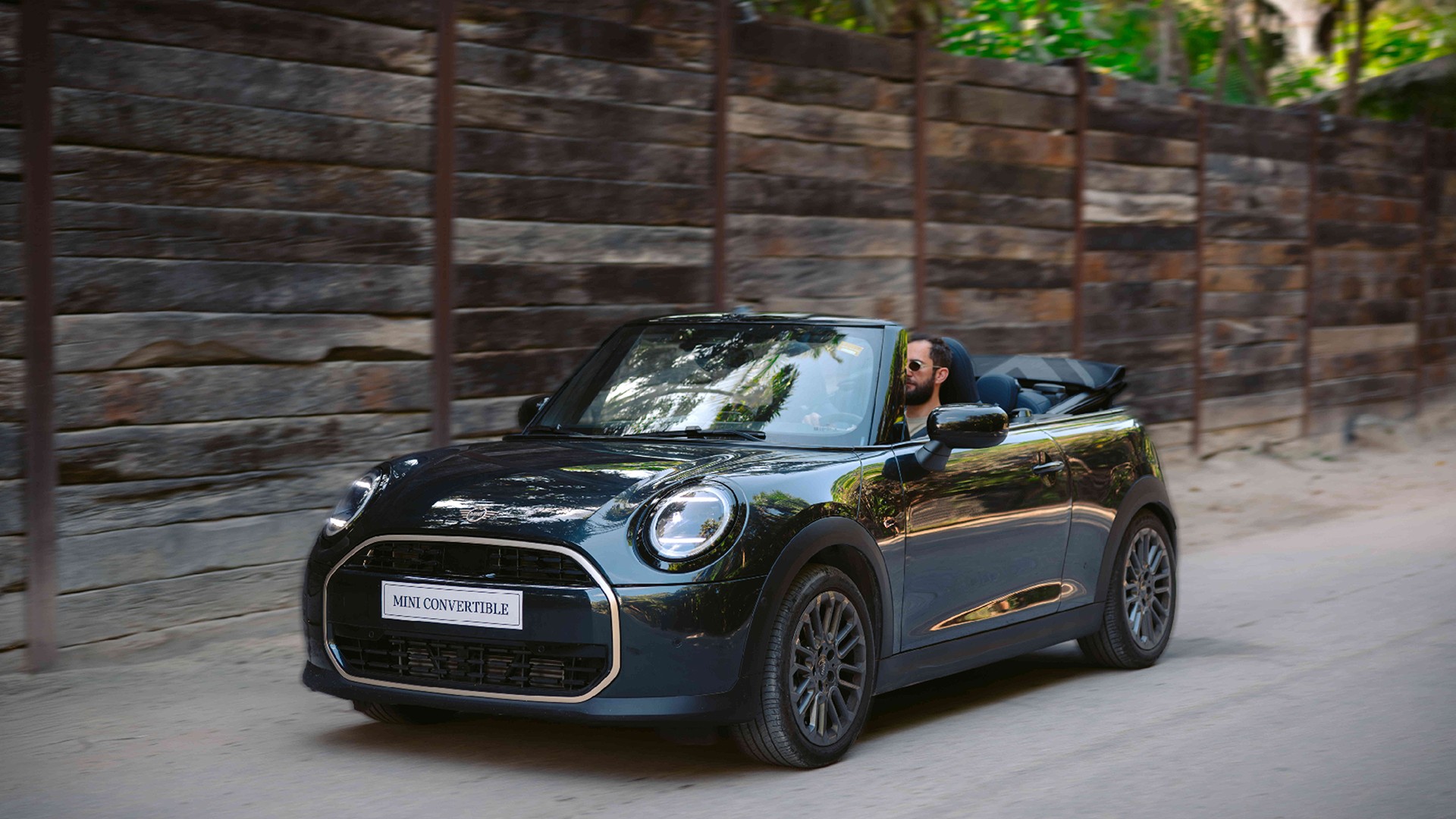 Rear left view of the MINI Cooper Convertible in Sunnyside Yellow parking.